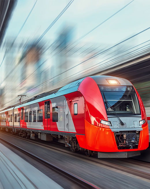 Image of a red and silver train in sharp focus, railway track and background blurry