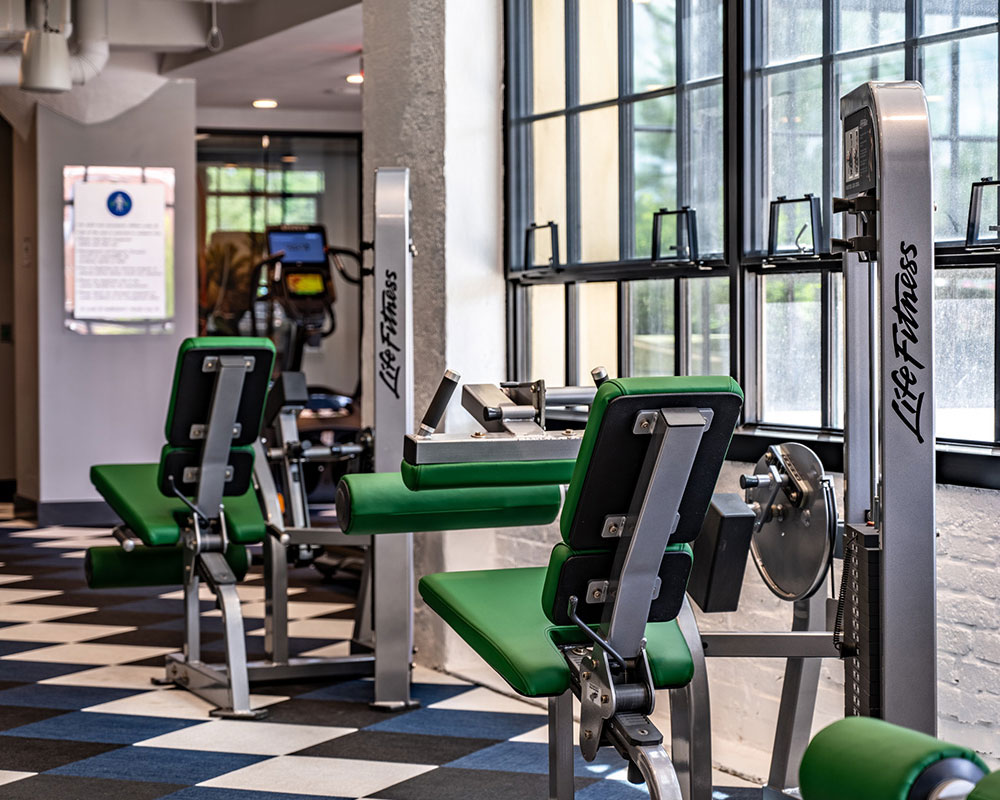 Leg press machines in an indoor gym with tile floors